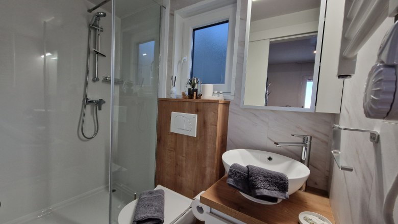 Badezimmer 2 Johannesbachklamm Chalet, © Johannesbachklamm Chalet Modernes Badezimmer mit Dusche, Waschbecken und Toilette.