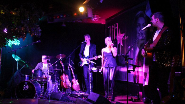 Veranstaltungen im Preiner Stadl, © Scharfegger’s Raxalpen Resort Bandauftritt im Preiner Stadl mit Sängerin und Musikern auf der Bühne.