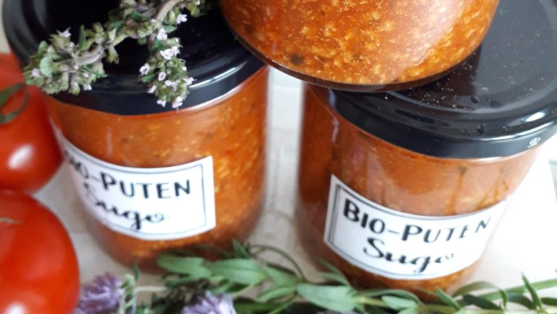 Bio-Putensugo, © Biohof Puchegger Gläser mit Bio-Puten Sugo, daneben Tomaten und Kräuter.