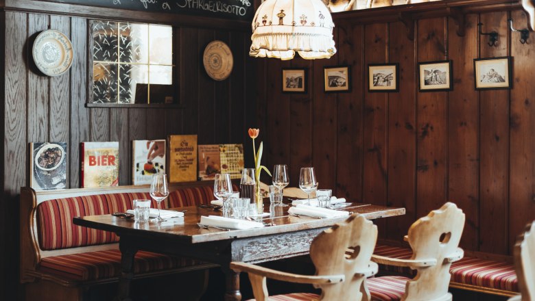 The Bucklige Welt tastes sooo good, © Niederösterreich Werbung/David Schreiber Cozy restaurant with wooden walls, red striped benches and a table setting.