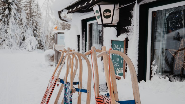 Enzianhütte, © Nixxipixx Fotografie & Design e.U. Nicole Seiser Verschneite Hütte mit Schlitten davor.