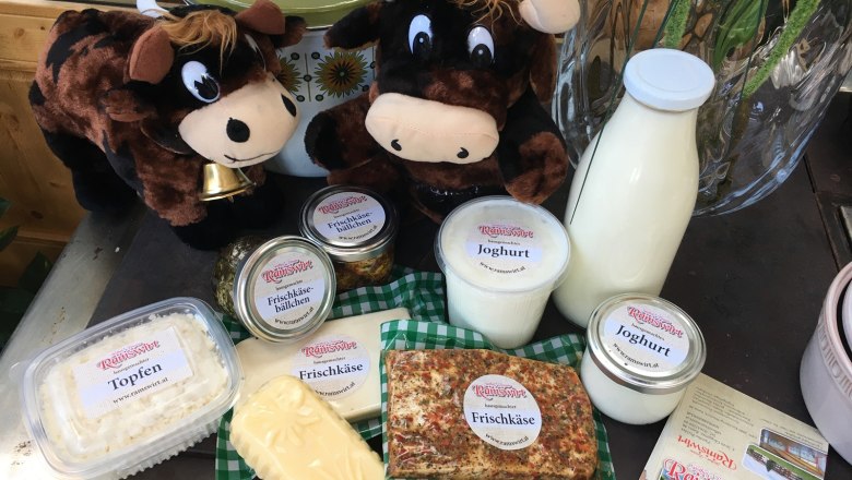Milchprodukte, © Ramswirt Verschiedene Milchprodukte mit zwei Plüschkühen auf einem Tisch.