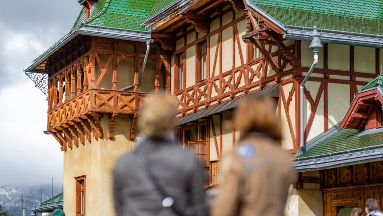 Roof terrace, © Wiener Alpen - Kremsl Historic building with green roof and half-timbering, blurred people in the foreground.