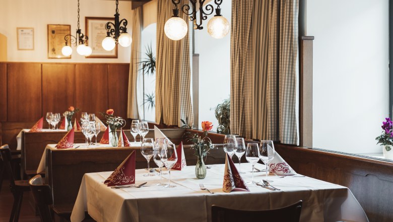 Refreshments in Krumbach, © Niederösterreich Werbung/David Schreiber Cozy restaurant with laid tables, wine glasses and flower vases.
