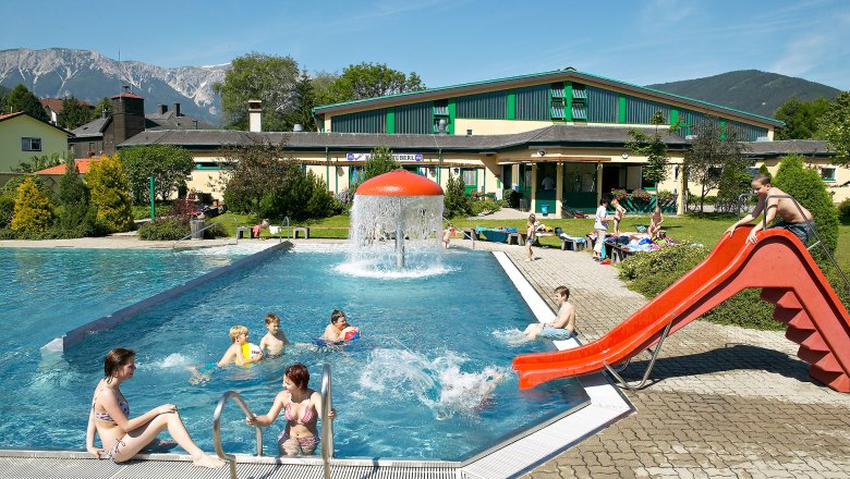 Puchberg outdoor pool, © Tourismusbüro Puchberg Outdoor pool with slide and mushroom fountain, surrounded by mountains.