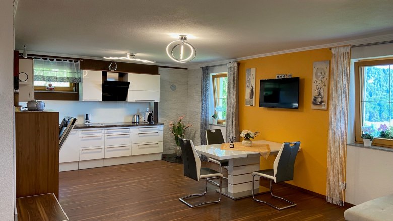 Wohnküche, © Wiener Alpen Moderne Wohnküche mit Esstisch, Stühlen und Einbauküche.