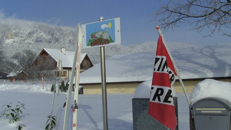 Langlaufen, © Reep Winterlandschaft mit Skiern, einem Schild 'Haus Bergblick' und einer 'Zimmer frei'-Fahne.