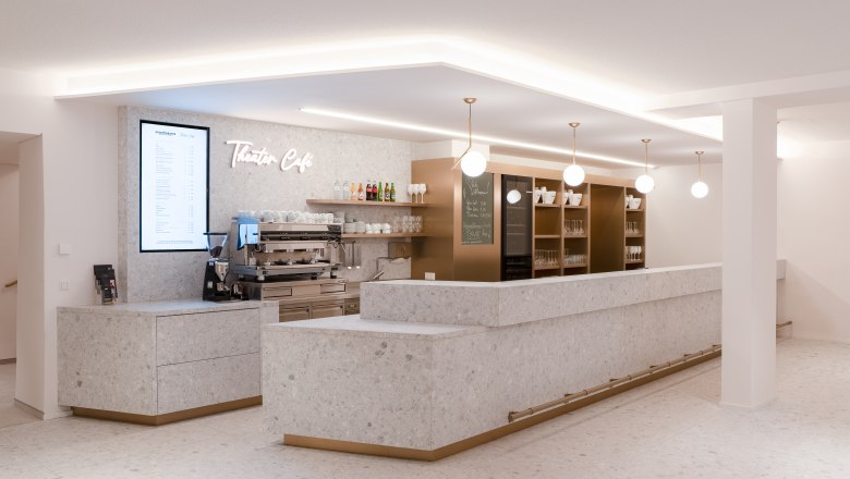 Theater Café: Moderner Treffpunkt für Genießer, © Alex Schwarz Photography Modernes Theatercafé im Stadttheater Wiener Neustadt mit heller Steinoptik, stilvollen Lampen und einladender Bar