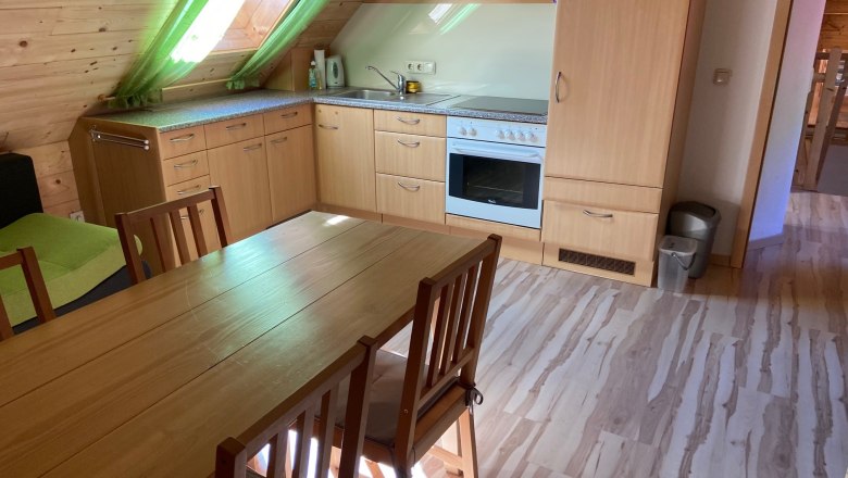 Ferienwohnung, © Wiener Alpen Küche in einer Ferienwohnung mit Holzmöbeln und Dachfenster.
