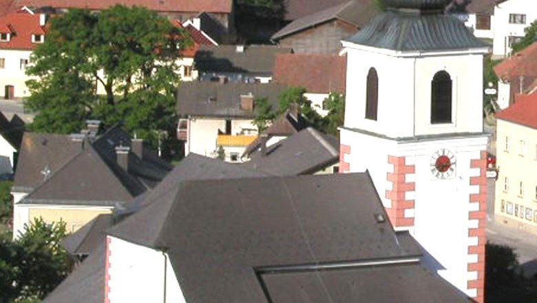 Pfarrkirche Hochneukirchen, © Gemeinde Hochneukirchen-Gschaidt Pfarrkirche Hochneukirchen mit umliegenden Gebäuden und Landschaft.