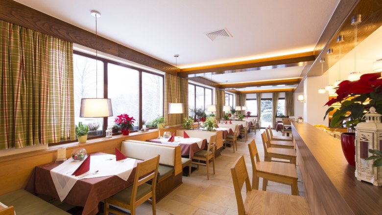 Restaurant, © Hotel Belvedere Innenansicht eines gemütlichen Restaurants mit Holzmöbeln und großen Fenstern.