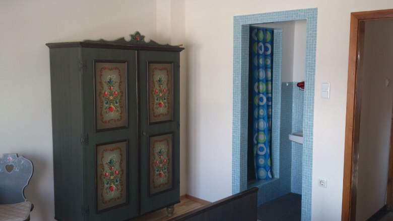 BaBioL Reichenau, © BaBioL Innenraum mit bemaltem Schrank und blau gefliestem Badezimmer.