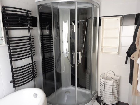 Bathroom with shower, © bed and pool Modern bathroom with shower cubicle, bathtub, towel radiator and laundry basket.