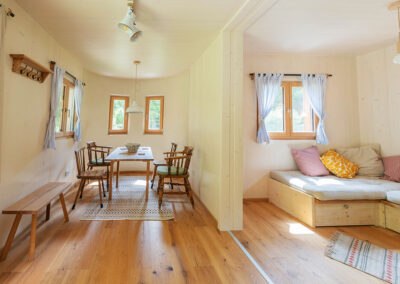 Huberto modular house, © Carina Rebler Interior view of a cozy modular house with dining area and sitting area.