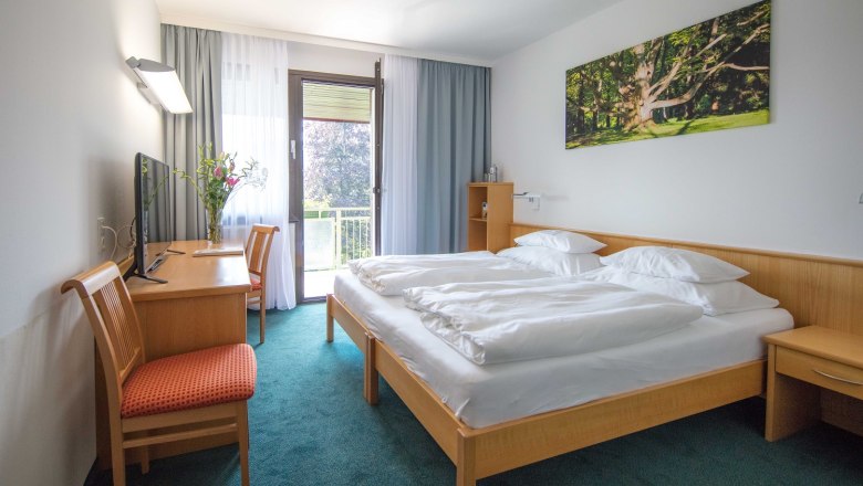 Rooms at the Parkhotel Hirschwang, © Friedl & Partner Hotel room with double bed, desk, chair and balcony.