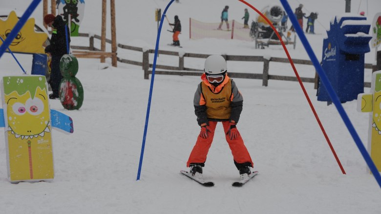 Semmering Ski School, © Seidl A child in ski equipment passes through an archway at the Semmering ski school.