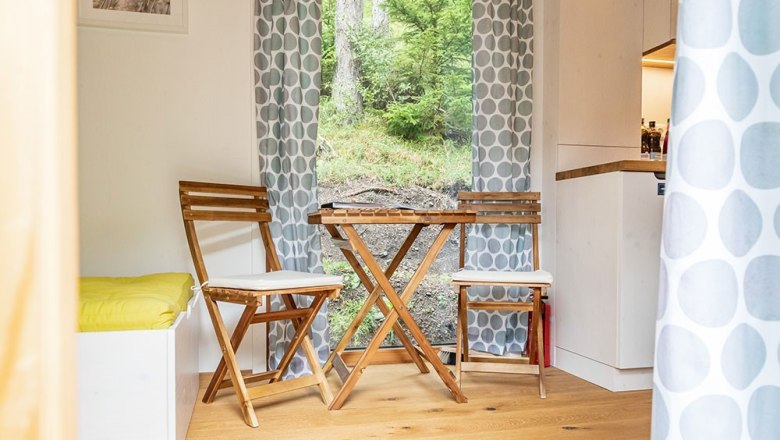 Sitzbereich Ronja, © WW Wohnwagon GmbH Gemütlicher Sitzbereich mit Holzmöbeln und Blick ins Grüne.