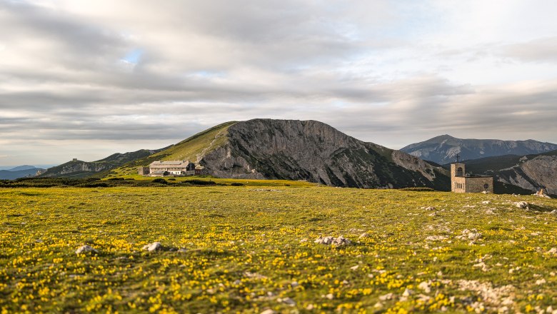 Am Raxplateau, © Kai Weidinger Berglandschaft mit Wiese und Gebäuden am Raxplateau.