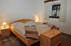 Ferienhaus Haltberghof, © Claudia Alber Gemütliches Schlafzimmer mit Holzmöbeln und Doppelbett.