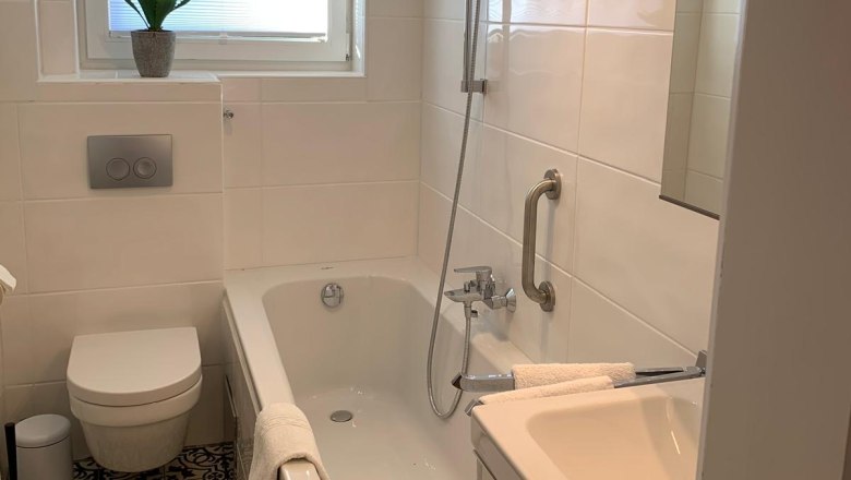 Bad WC, © Marianne Gschaider Modernes Badezimmer mit Badewanne, WC und Waschbecken.