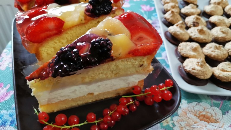 Selbstgemachte Mehlspeisen für jeden Geschmack, © Wiener Alpen Obstkuchen mit Beeren und Kekse auf einem Tisch.
