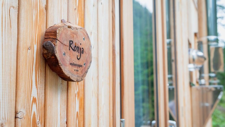 Wohnwagon Ronja, © WW Wohnwagon GmbH Holzschild mit der Aufschrift 'Ronja' an einer Holzwand.