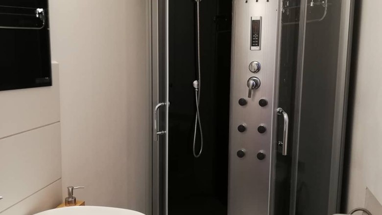 Bad Doppelzimmerl, © Familie Weibels Modernes Badezimmer mit Duschkabine, Waschbecken und Toilette.