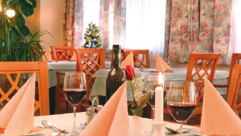 Gediegen speisen, © Johannes Geier Elegantes Restaurant mit gedecktem Tisch, Weingläsern und Kerzen.