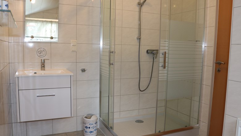 Badezimmer Gaeste 4, © Gruber Claudia Modernes Badezimmer mit Dusche, Waschbecken und Spiegel.