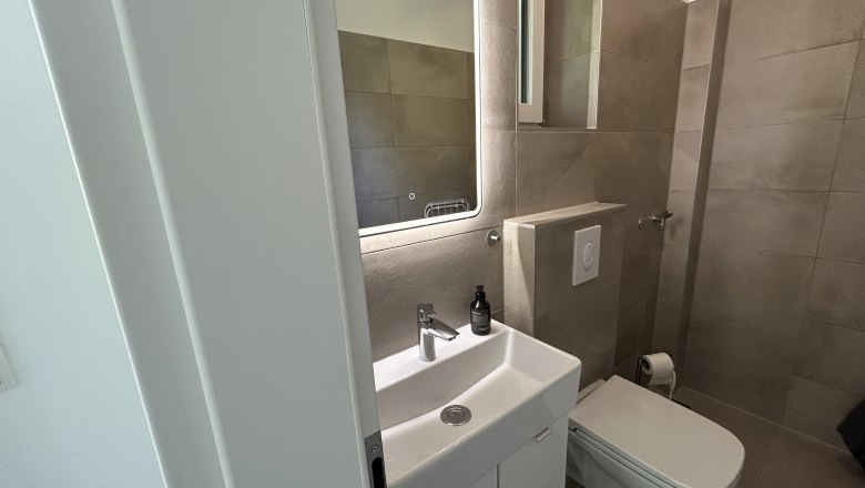 Tiny House, Feigenterrasse am Semmering, © Stupacher Modernes Badezimmer mit Waschbecken, Spiegel und Toilette.