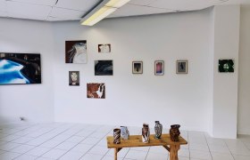 kunstraum-konrad, © Stefan Schuster Galerieraum mit Kunstwerken an der Wand und Keramiken auf einem Holztisch.