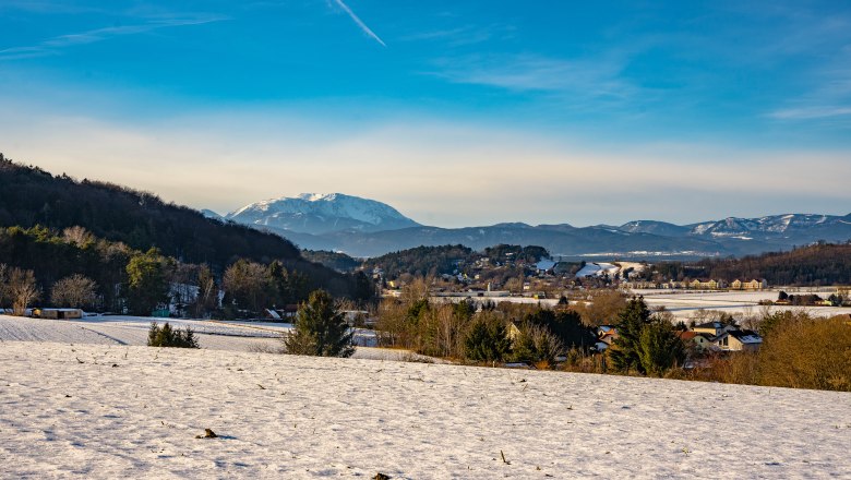 Winterlandschaft um den Gläsernen Kreuzweg in Bad Erlach, © Wiener Alpen, Flotoanker - Luckerbauer Winterlandschaft mit schneebedeckten Feldern und Schneeberg, im Hintergrund in Bad Erlach.