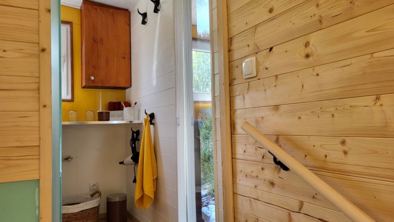 Interior view of a bathroom with wood paneling and yellow accents.