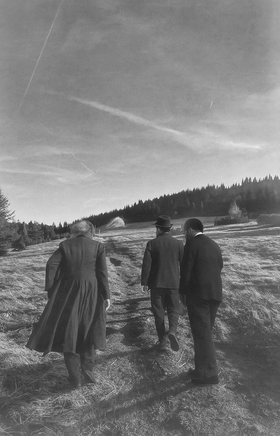 Schwarz weiß Foto, dass drei historische Personen von hinten zeigt, wie diese auf der Rax gehen