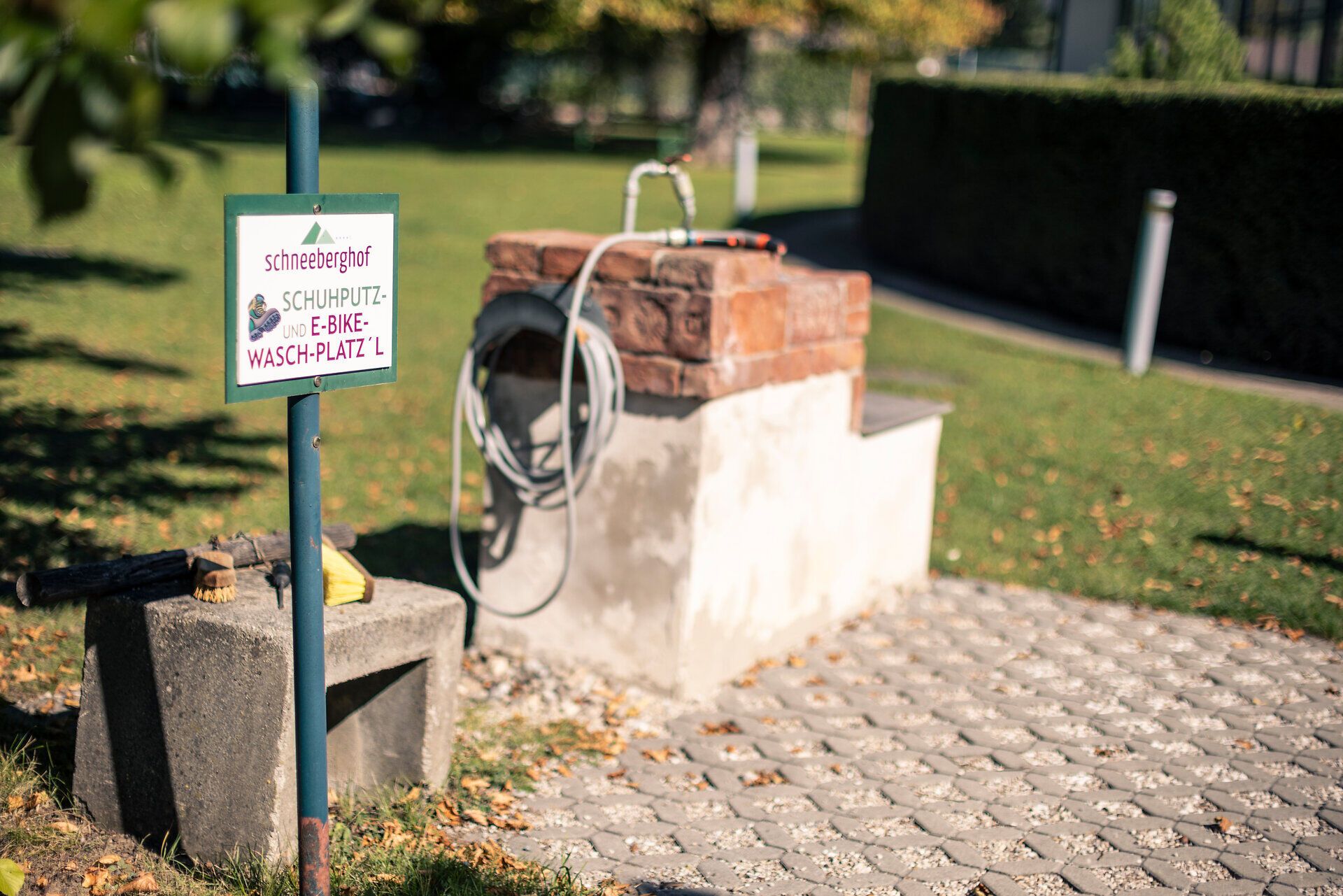 Beim Hotel Schneeberghof findet man ein eigenes Schuhputz- und E-Bike-Waschplatzl, gekennzeichnet mit eigenem Schild und ausgestattet mit Wasserschlauch und Bürsten.