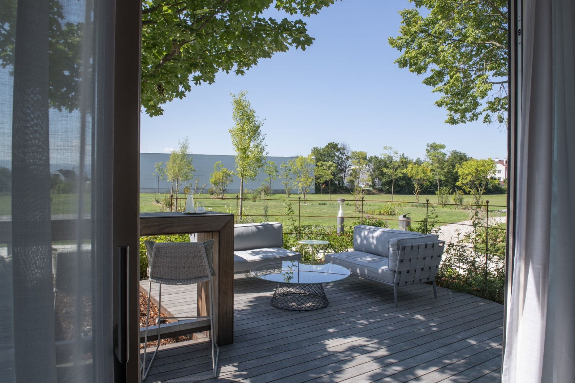 Modernes Gebäude mit der Aufschrift 'Le Parc' und Bäumen im Vordergrund.