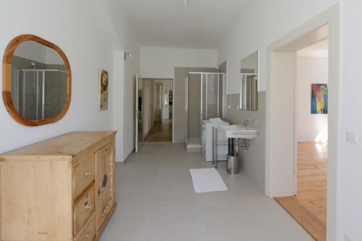 Innenansicht eines modernen Badezimmers mit Holzmöbeln und Dusche.