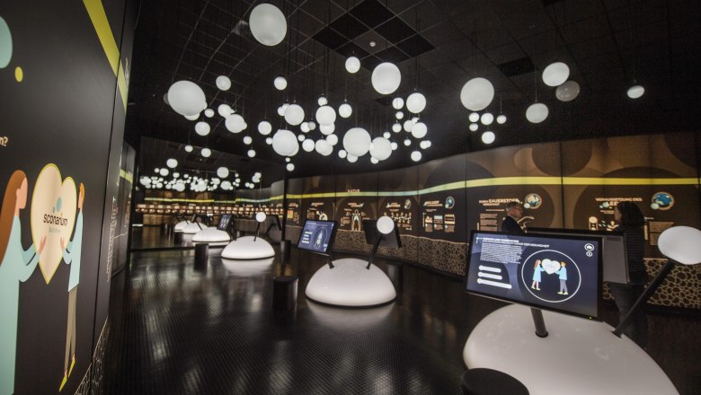 Ausstellungsraum dunkel mit wei&szlig;en Kugeln 