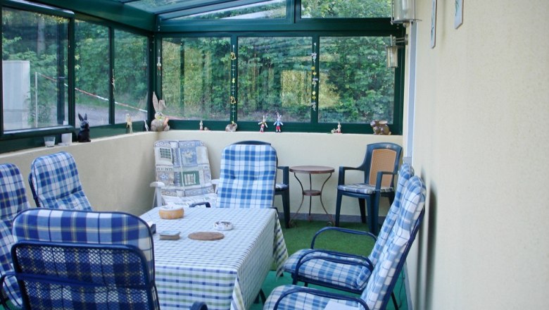 Winter garden with table and chairs, decorated with figures.