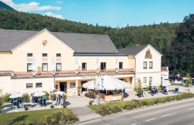Theater Reichenau mit Menschen und Sonnenschirmen davor.