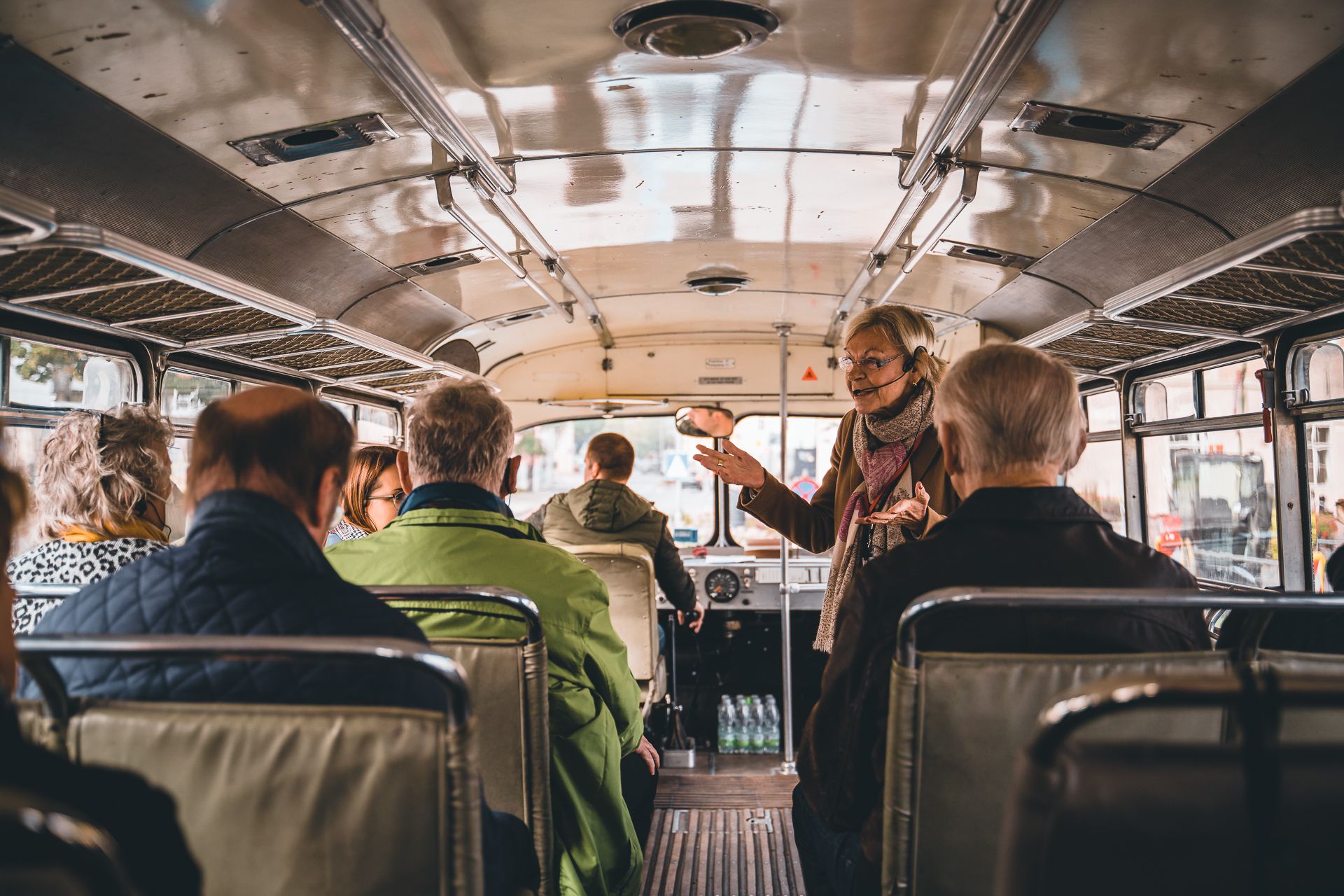Einige Leute fahren mit dem Oldtimerbus und schauen sich die Stadt an. 