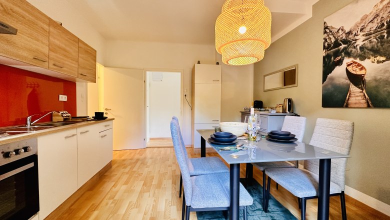 Moderne Küche mit Esstisch und Hängelampe.