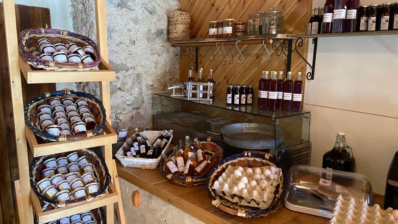 Shelf with jams, bottles and eggs in a farm store.