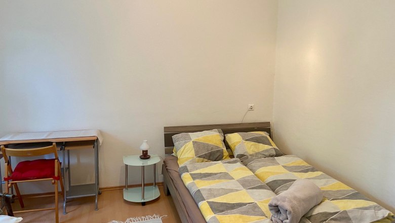 Schlafzimmer mit Doppelbett, Schreibtisch und Stuhl.