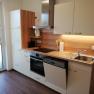 Modern kitchen with wooden worktop, sink, stove and dishwasher.