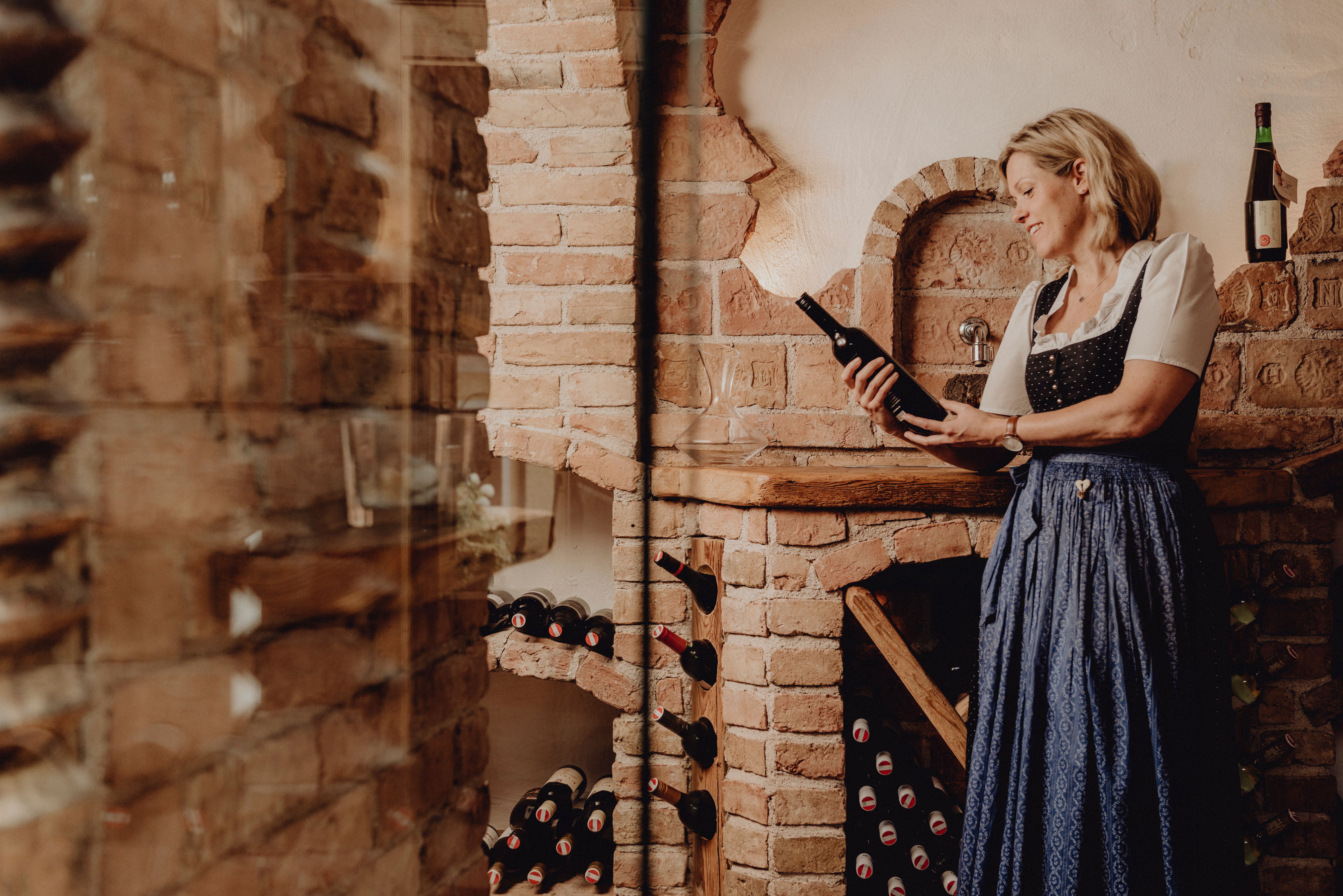 Eingang des Gasthofs Zur Schubertlinde mit zwei Personen in traditioneller Kleidung.