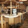 Innenansicht einer gem&uuml;tlichen Bar mit Holzm&ouml;beln und Theke.