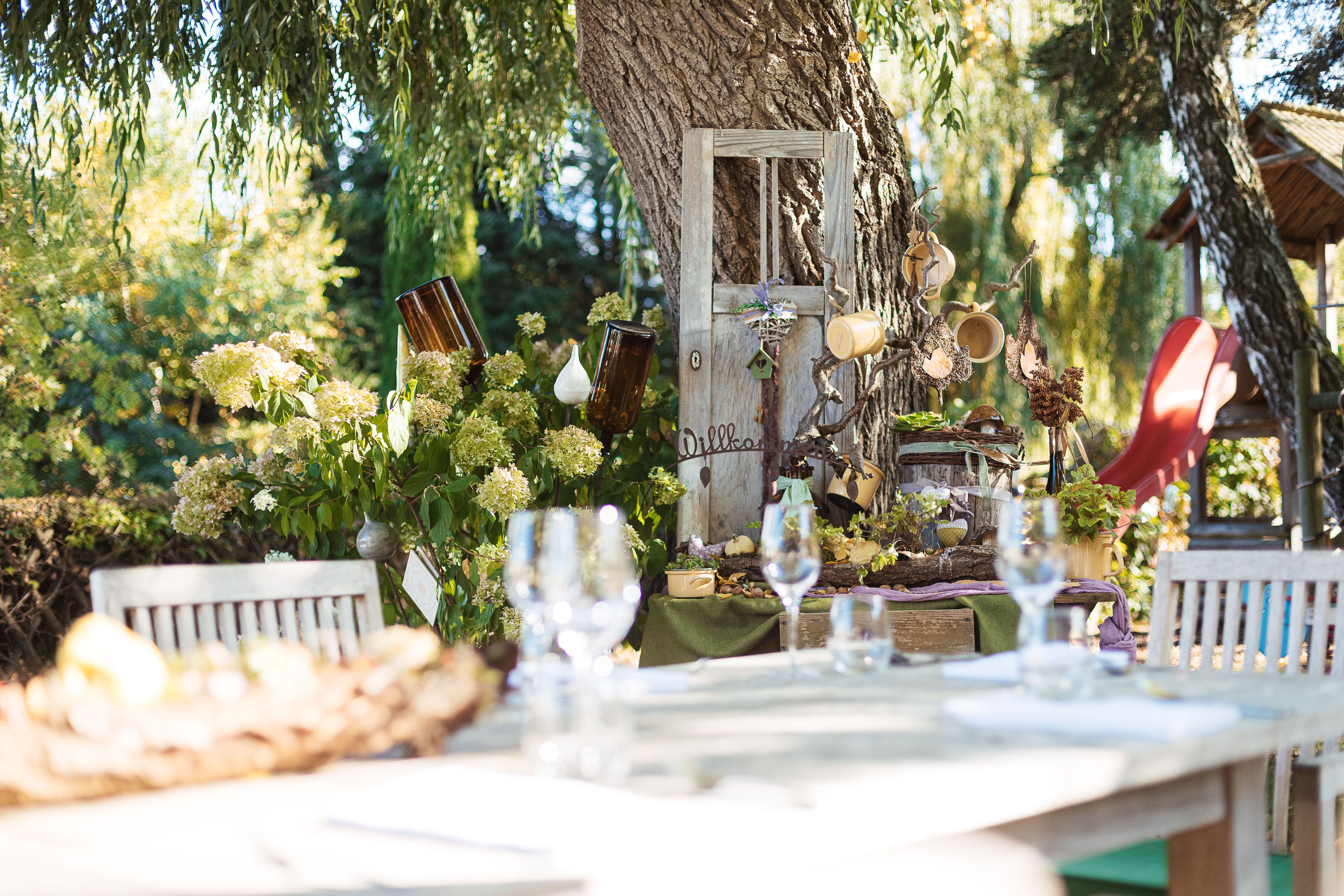 Ein gemütlicher Wintergarten mit hellen Tischen und Stühlen und ansprechender Dekoration.