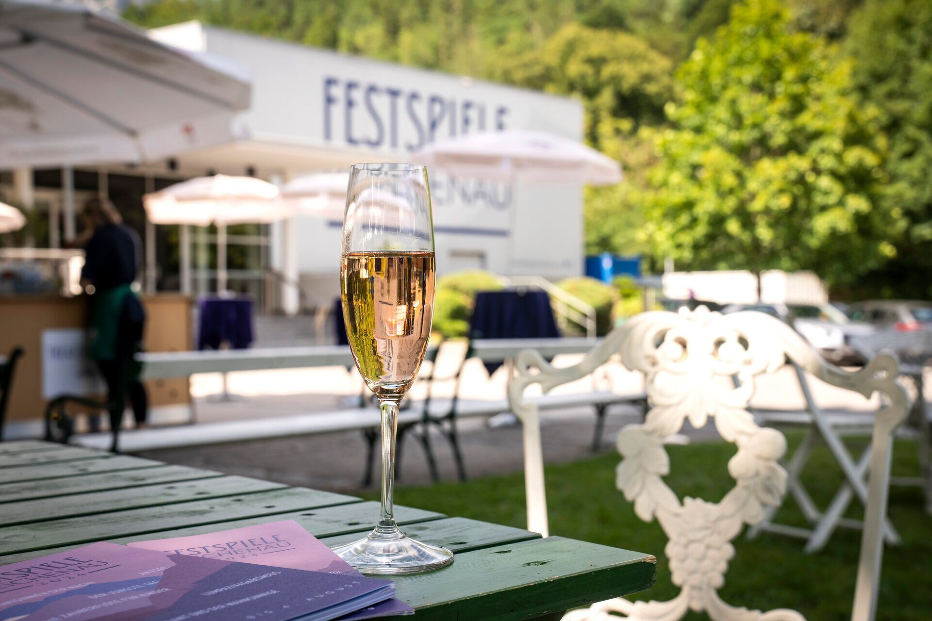 Ein prickelndes Glas Sekt steht auf einem rustikalen Tisch, umgeben von der malerischen Kulisse der Wiener Alpen. Die sanften Hügel und das grüne Gras laden dazu ein, die Seele baumeln zu lassen und die Schönheit der Natur zu genießen. Hier, wo Kultur und Natur harmonisch verschmelzen, wird jeder Moment zum unvergesslichen Erlebnis.