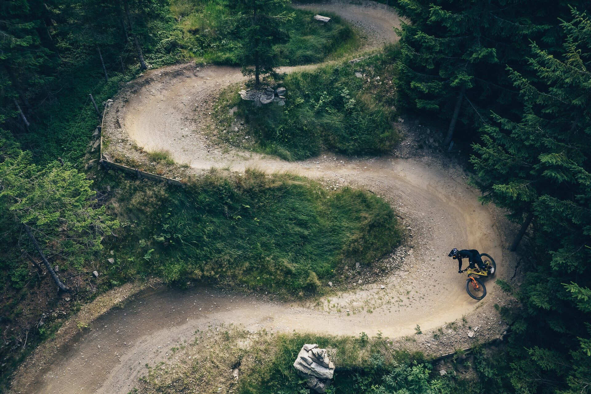 Die kurvenreiche Strecke schlängelt sich durch dichte Wälder, während Mountainbiker mit Begeisterung die Herausforderung annehmen. Die frische Bergluft und das Rascheln der Blätter schaffen eine unvergessliche Atmosphäre für Abenteuerlustige.